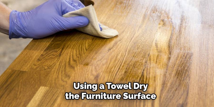 Using a Towel Dry the Furniture Surface