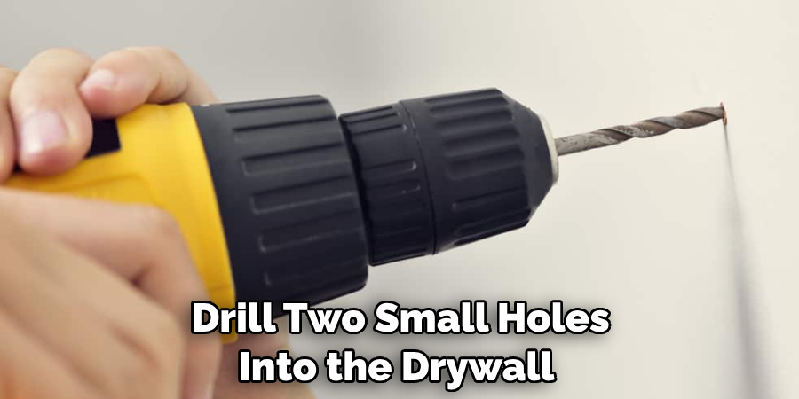 Drill Two Small Holes Into the Drywall 